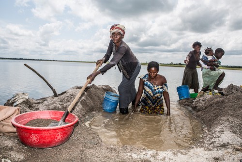 Village de Muchanga, zone d’extraction minière illicite, Kolwezi, province du Katanga, RDC. Une des tâches assignées aux femmes dans la carrière est de laver le minerais brut. Elles trient et tamisent toute la journée dans l’eau du fleuve.